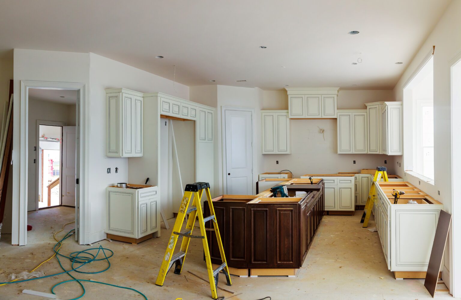 Installation of kitchen. Custom kitchen cabinets in various stages of installation base for island in center