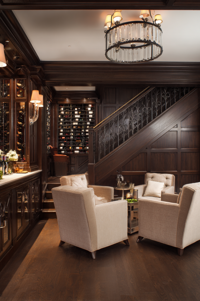 Elegant basement renovation featuring dark wood paneling, built-in wine cellar, staircase detail, and cozy lounge seating