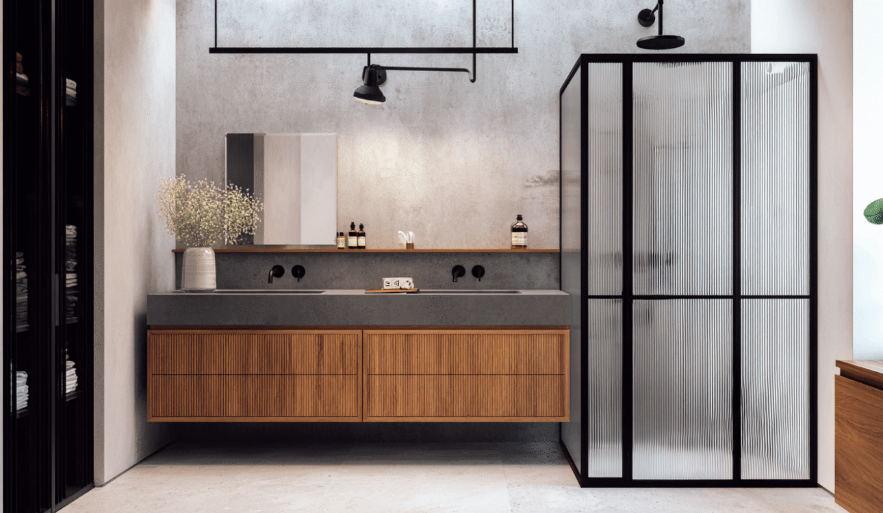 Modern double vanity bathroom renovation in Toronto with wood cabinetry, black fixtures, and textured glass shower partition