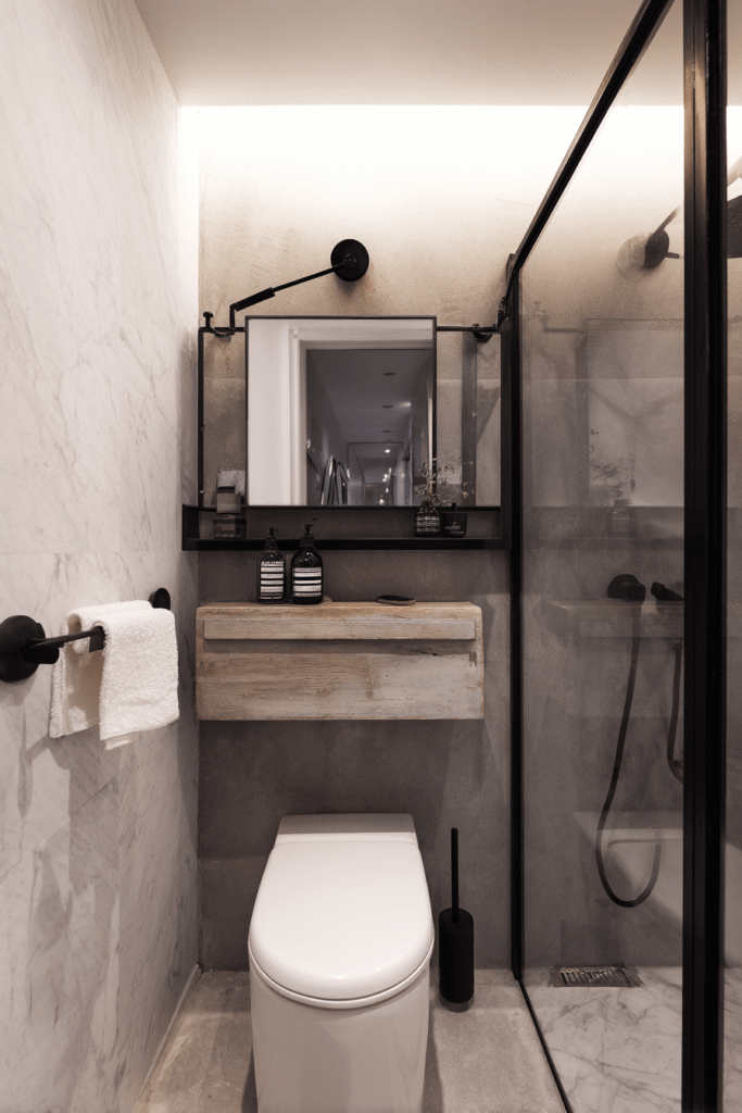 Small modern bathroom renovation in Toronto featuring compact layout, black fixtures, floating vanity, and glass shower enclosure