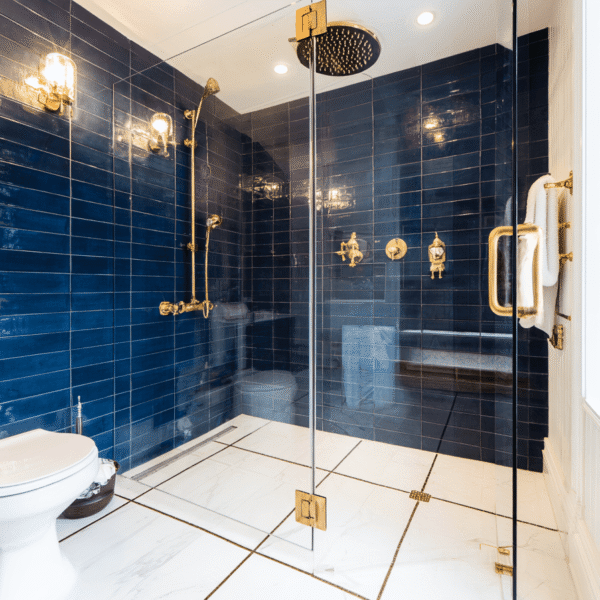 Modern walk-in shower bathroom renovation Toronto DIY with blue tiles and gold fixtures