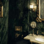 Luxury bathroom renovation Toronto featuring green marble walls, gold fixtures and classic vintage mirror design